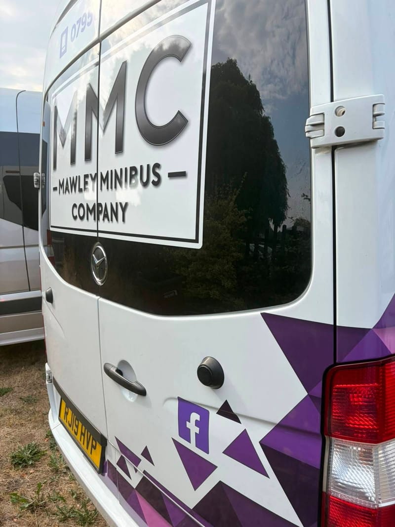 The MMC logo and purple triangle livery on the back of a Mawley Minibus