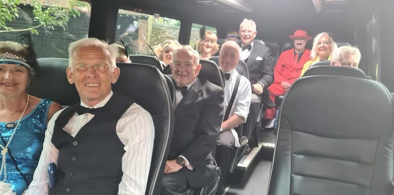 Passengers in 1920s fancy dress smiling on board a Mawley Minibus